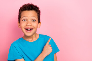 Poster - Photo portrait of charming small boy astonished excited point empty space wear trendy blue garment isolated on pink color background