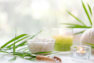 Wall Mural - Thai Spa Treatments aroma therapy salt and  sugar scrub massage with bamboo leaves with candle, white background. Thailand. Healthy Concept