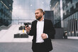 © BullRun - Serious businessman with smartphone in downtown