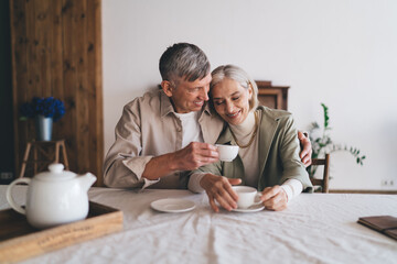 Loving couple having hot beverage at home