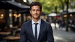© TAMA KUN - Portrait of a young businessman standing in a city street, looking at camera.