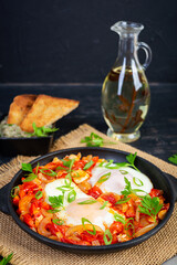 Wall Mural - Shakshuka with grilled bread. Fried eggs with tomato, pepper, garlic and herbs