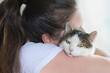 © Tunatura - Woman tenderly caressing cat, holding it in the arms. Felinotherapy concept.