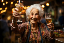 A Cute Gray-haired Elderly Woman Raises A Glass Of Beer In A Restaurant Bar And Smiles Cheerfully. Active Lifestyle In Old Age