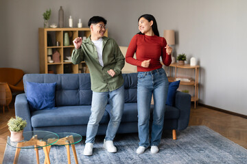 Wall Mural - Loving Young Asian Spouses Dancing Together At Home, Having Party