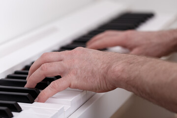 Wall Mural - Young man playing on white modern piano, home learning, music education, composing