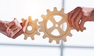 two business people united wooden cogs gears, close-up