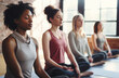A diverse group of young women in a yoga studio learning breathing techniques to decrease their levels of stress and anxiety, and to attain better sleep quality.breathwork concept