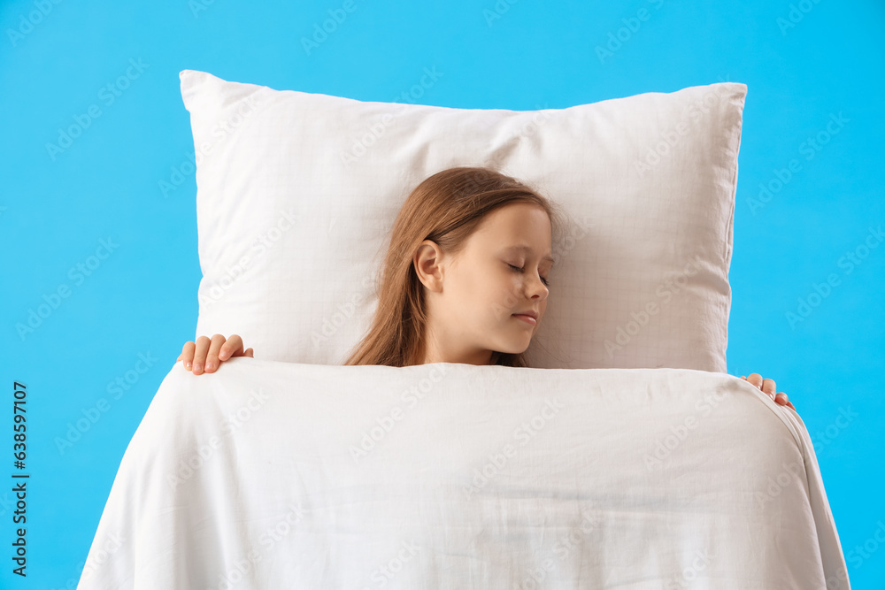 Sleeping little girl with pillow and blanket on blue background, top view