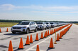 Outdoor drive-through testing facility with cars lined up. 