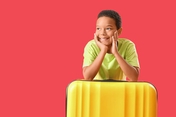 Poster - Little African-American boy with suitcase on red background