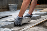 Fototapeta Przestrzenne - DIY project - male hands paving outdoor patio with cement tiles