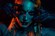Photo of sexy attractive mysterious lady wear viking clothes applying ritual make up isolated dark blue color background