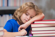 © Volodymyr - Tired school boy, bored pupil at school. School books and education concept. Child pupil reading book in a book store or school library. Kid study read.