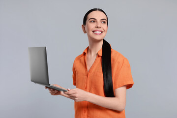 Wall Mural - Happy woman with laptop on light gray background