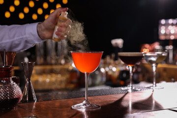 Poster - Bartender preparing fresh Martini cocktail in glass at bar counter, closeup