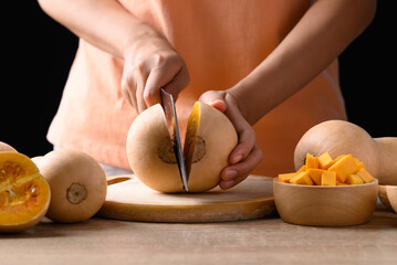 Wall Mural - Butternut squash pumpkin with hand holding knife and cutting, Organic vegetable in autumn season