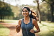 © PRASANNAPIX - Young woman running and listening music at public park