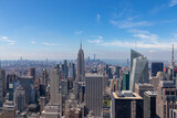 Fototapeta  - Vibrant urban skyline with towering skyscrapers and impressive architecture seen from Top of The Rock in New York. Empire State Building and One World Trade Center in the frame. Modern and lively city