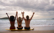 © Wosunan - Rear view of three friends sitting on surfboard and looking at sea