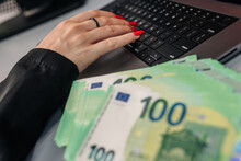 A Woman Counts Expenses On A Laptop, Calculates Finances And Expects To Make Purchases. Business Woman Concept Behind Laptop With Euro Currency.