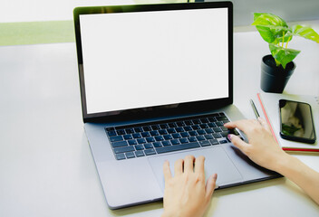 Poster - Businesswoman working on laptop computer with blank withe screen, laptop template with background office concpet.