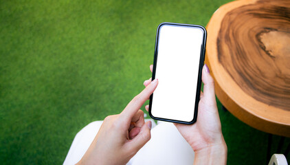 Poster - Close-up of woman hand holding a smartphone white screen is blank the background is blurred. obile phone Mockup.
