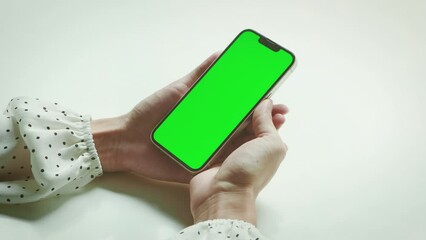 Poster - Woman with Green Screen Chroma Key Smartphone. Young adult using Internet, Social Media, Online Shopping with Mobile Phone Device. Focus on Green Display.
