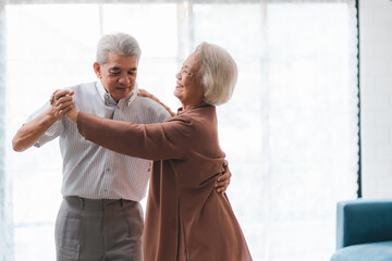 Wall Mural - Asian happy senior couple having fun and relax dancing together at home, love, romantic elderly mature person or husband and wife lifestyle, aged retirement man and woman family are smiling to dance