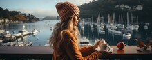 Girl Traveller Standing On Ferry Boat, Staring Out At The Water While Holding A Coffee Cup.