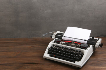 Fototapete - vintage typewriter on the table with blank paper on wooden desk - concept for writing, journalism, blogging