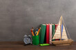 Education is a journey concept, toy boat and books on the wooden table, inspiration for a writing a fairy tale. Elementary school supplies