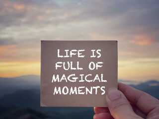 Wall Mural - Motivational and inspirational wording. Life Is Full Of Magical Moments written on a notepad. With blurred styled background.