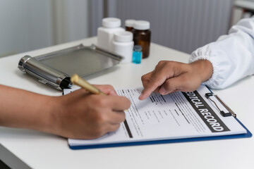 Wall Mural - Close-up of a professional doctor and a patient signing a medical insurance policy. doctor notes healthcare paperwork