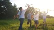 © maxximmm - children run through the meadow in the park with toys in their hands. happy family kid dream concept. a group of little kids have fun together and play with flying kites toy lifestyle airplane