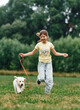 © standret - Cute little girl is with golden retriever dog on the field