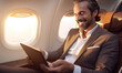 © Andrii IURLOV - Smiling happy businessman flying and working in an airplane in first class, Man  sitting inside an airplane using laptop.