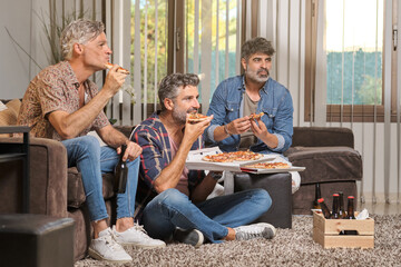 Cheerful friends eating pizza together at home