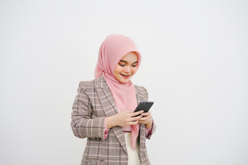 Wall Mural - Portrait of a young muslim businesswoman pink hijab reading a message on the mobile phone isolated on white background.