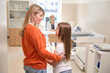 © Viacheslav Yakobchuk - Mom in orange sweater and pretty daughter are in pediatric office