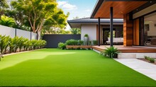 Contemporary Lawn Turf With Wooden Edging In Front Yard Of Modern Australian House. Artificial Grass With Clean Design And Boundary Decoration