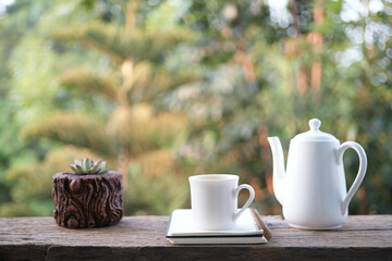 Wall Mural - Ceramic white tea pot and tea cup with cactus mini pot