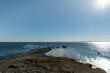 Panoramic winter view along coastline of Greenwich Point, Greenwich, CT, USA with ice or slush forming at edge of coastline with Long Island in background against a clear blue sky
