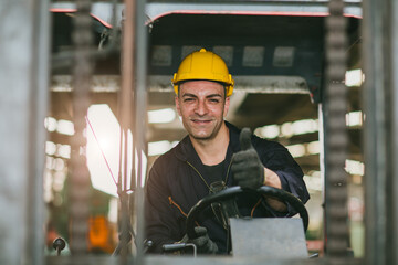 Portrait happy forklift driver wearing safety helmet and vest enjoy working transporting goods in warehouse shipping cargo