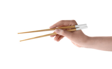 Wall Mural - Woman holding pair of wooden chopsticks on white background, closeup