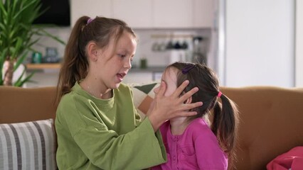 two young kids sisters have fun, hugging and fooling around