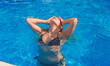 © T.Den_Team - European blonde beautiful woman in pool. Travels and vacation concept, blue water and tan body
