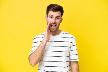 Wall Mural - Young caucasian man isolated on yellow background with surprise and shocked facial expression