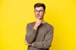 Young caucasian man isolated on yellow background having doubts and thinking