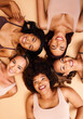 © Anela/peopleimages.com - Beauty, above and portrait of a diversity of women with smile for skincare isolated in studio brown background together. Support, happy and group of friends on a floor for skin, care and face makeup